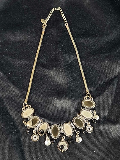 Vintage-style statement necklace featuring a silver-tone chain and black cabochon accents