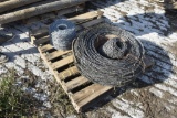 pallet with new roll of barbed wire, one partial, and big roll of barbed wire