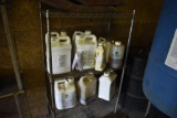 Stainless steel metal shelf with 7 containers of weed killer and smaller jugs of chemicals