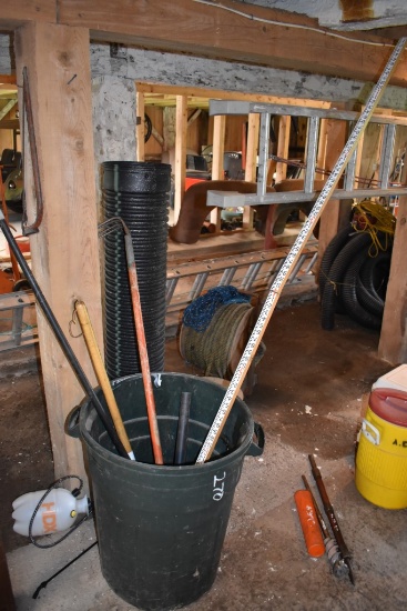 Garbage Bin With Potato Fork, Weeder, Measuring Stick, And A Broom Handle, And A Pump Sprayer