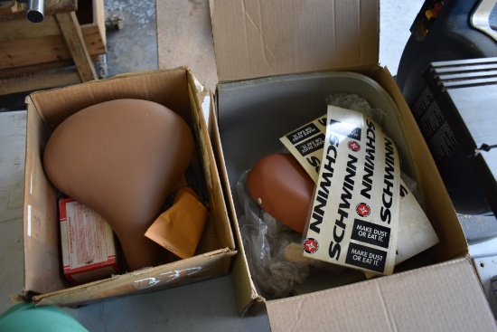 Two Boxes Of Bike Seats And Parts