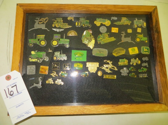 John Deere collection of advertising pins in display case