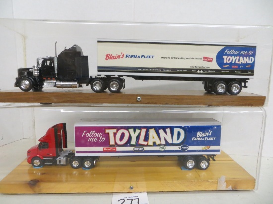 2 Toy Land semi's w/trailers in cases, Blains Farm & Fleet, Kenworth & Volv