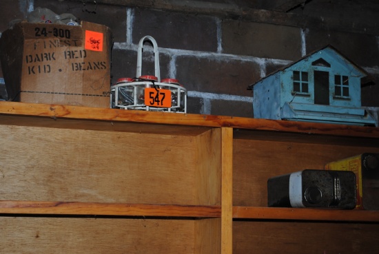 Contents of wood shelf on wall including bird feeder, live trap, glass blocks, insulators, hardware,