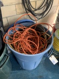 Plastic garbage can with assorted electric cords and wiring and extension cords