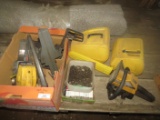 Assortment of McCulloch disassembled chainsaw engines, chainsaw chains, carrying cases