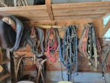 Assorted old leather draft horse harness pieces, halters, bits, brass bells and wagon parts