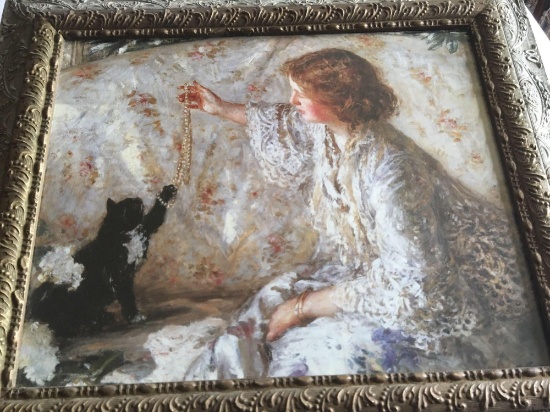 Ornate frame with a picture of a girl playing with her cat