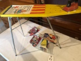 Child's ironing board, iron, crayons, and Nascar cars