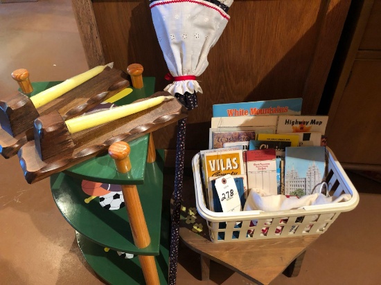 Tiered, wood corner-shelf; heart-shaped stool, broom, various maps, and candle holders.