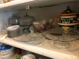 Various lidded glass cake plates, glass serving trays and porcelain lidded cookie jar.
