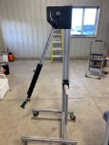Aluminum 4 caster rolling stand with adjustable top arm and main frame.