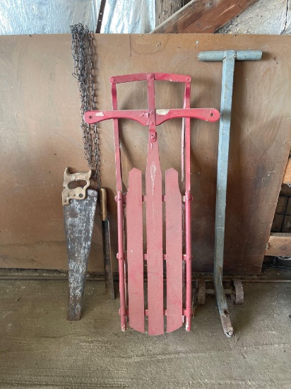 Steerable snow sled, handsaw, corn knife, light chain, two steel wheel mover.
