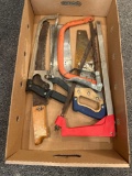 Box of assorted hack saws, wood saws, and machete
