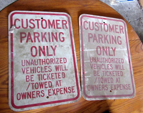 Pair of Customer Parking Only signs, one with Luedtke Homestead on backside