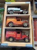 set of 3 wooden Coca-Cola delivery trucks on display