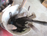 bucket of hand tools, axes, hammers, and saws
