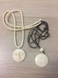 Lot of Two Hand-Carved Walrus Ivory Man in the Moon Pendants, One w/ Beaded Ivory & Leather Cord
