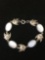 Oval 15x10mm White Cat's Eye Cabochon & Angelfish Charm Accented 7in Long Sterling Silver Bracelet
