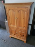 112. Wood entertainment cabinet with brass knobs. Unit has electrical outlets in upper portion of