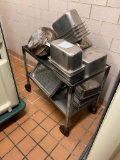 Stainless steel cart on casters with several stainless steel pans and trays