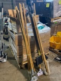 Group of assorted mop handles and brooms