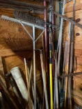 Large lot of assorted yard tools- rakes, hoes, post hole diggers