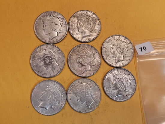 Eight mixed Peace Silver Dollars