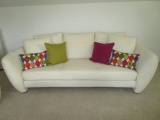 Beautiful White Leather Sofa w/Bright Cloth Covered Accent Pillows.