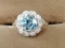 10 kt, y/g ring with 12.5mm round blue topaz, with ten (10) .01 spinels. Total weight 2.98 gms. Size