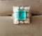 Ladies Size 7 1/2 14 kt y/g emerald and diamond ring with black background,