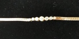 14 kt, y/g 7 1/2 inch, seven (7) diamond bracelet consisting of two (2) .06 ct. diamonds, two (2) .