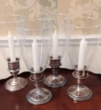 Four Sterling candlestick holders with shades