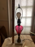 Glass cranberry edged lamp on marble base no shade approximately 21 inches tall