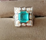 Ladies Size 7 1/2 14 kt y/g emerald and diamond ring with black background,