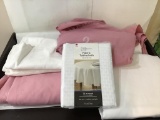Box of linens, tablecloths. Pink and white
