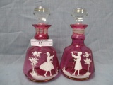 PAir of Mary Gregory dresser bottles on cranberry