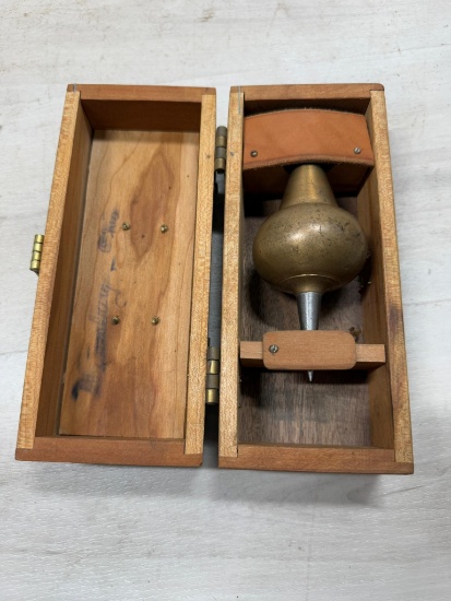 Inverted onion plumb bob in wooden storage box