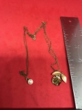 2 Necklaces, they are tangled together, one appears to be marked 12k, the other has a gold filled pe