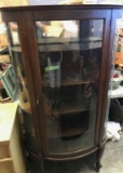 Bow Front Glass Curio Cabinet, on casters.  Appears to be all original,
