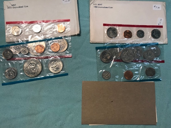 1973 and 1980 Uncirculated coin sets, enveloped show wear, cello packs do not