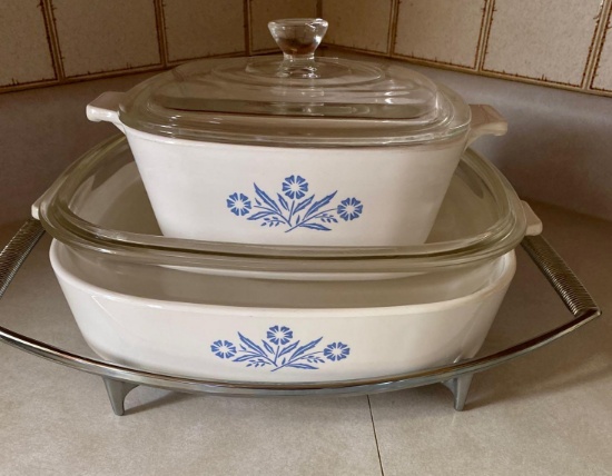 Two corningware dishes with lids and metal holder