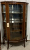 Antique curved glass curio cabinet on casters