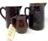 Three brown decorated crock pitchers