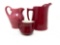 Three vintage cranberry stoneware pitchers