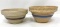 Two antique crock bowls with blue, brown and pink lines