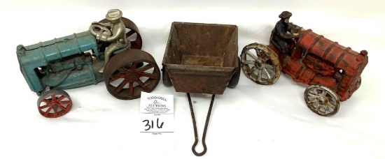 Two antique cast iron tractors and a cart