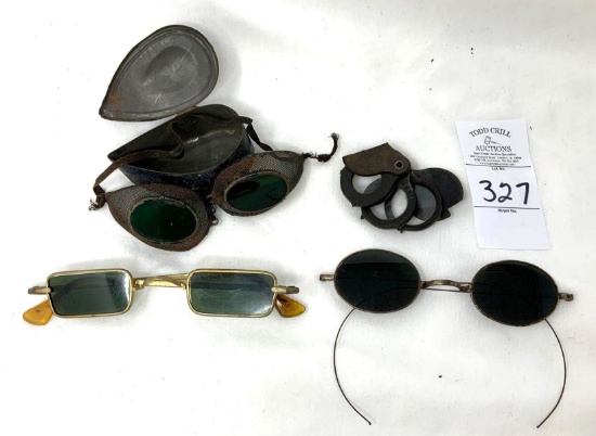 Antique safety goggles in a metal case, two pair of vintage sunglasses and eye Ioop