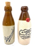 Two brown and white crock bottles, W. Ambrose ginger beer