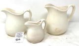Three white antique pitchers